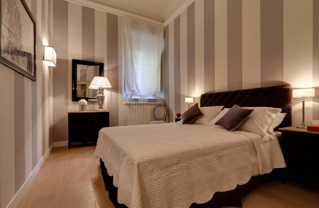 um quarto com uma cama grande e paredes listradas em Palazzo Branchi em Florença