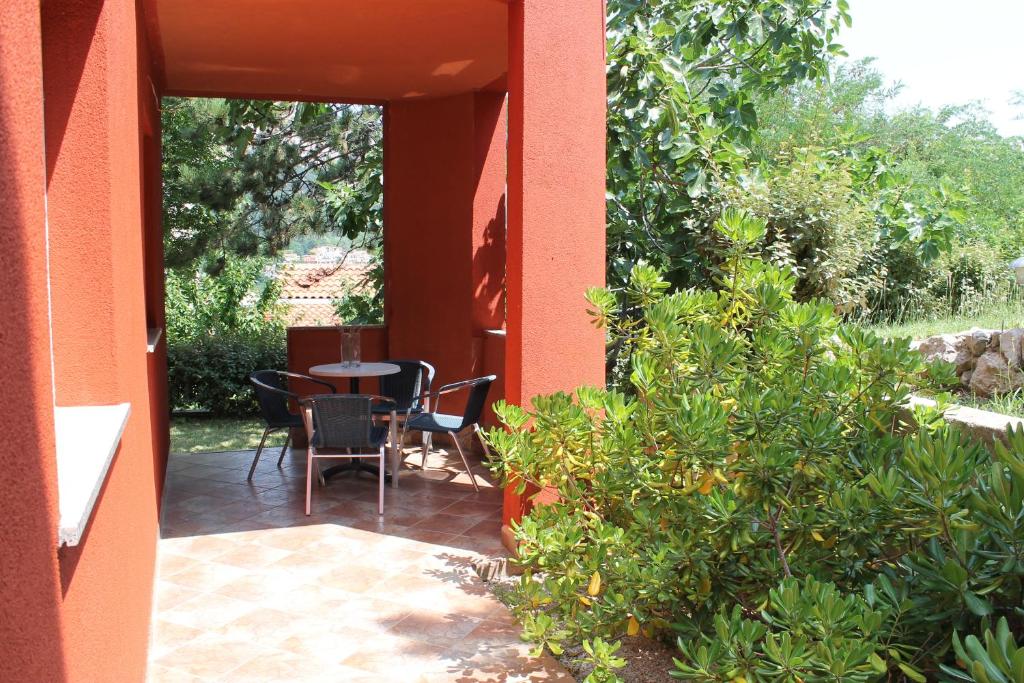 patio ze stołem i krzesłami na ganku w obiekcie Apartments Isabela w Bašce