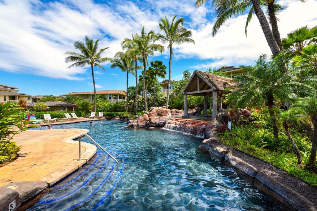 a pool in a resort with palm trees at Nihilani at Princeville 19C in Princeville