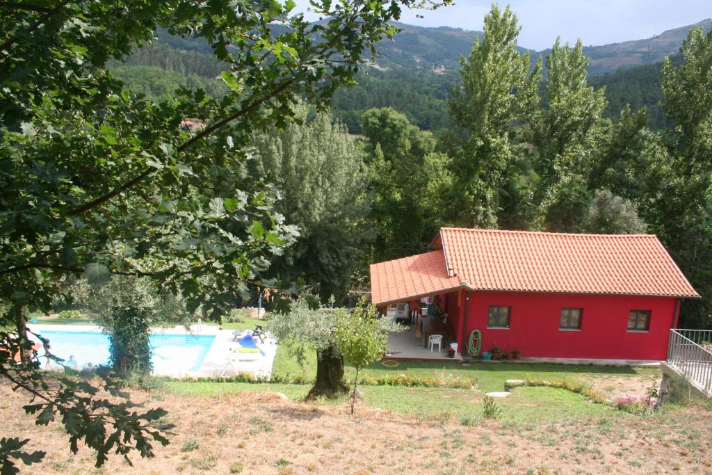 een rood huis met een zwembad en bomen bij Casas de Alvite in Cerva