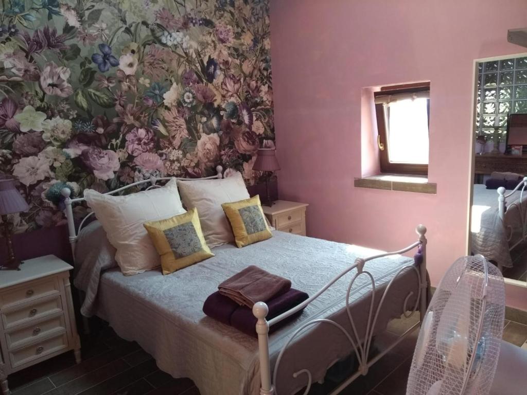 a bedroom with a bed with a floral wallpaper at Casa Beghino in Lama Mocogno