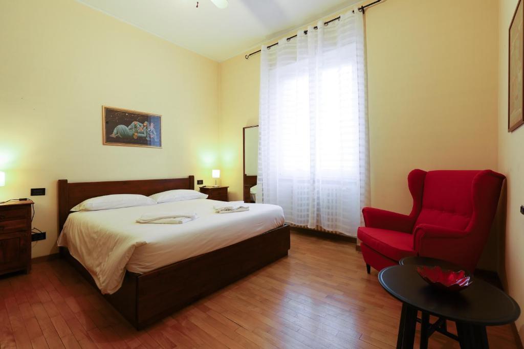 1 dormitorio con 1 cama y 1 silla roja en PrimoPiano - Ciardi en Milán