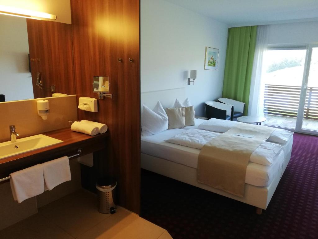 クレッヒにあるGolf Resort Klöchのベッドとシンク付きのホテルルーム