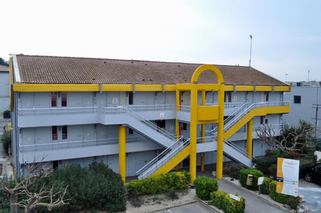 un bâtiment avec un grand escalier jaune devant lui dans l'établissement Premiere Classe Sete - Balaruc, à Balaruc-le-Vieux