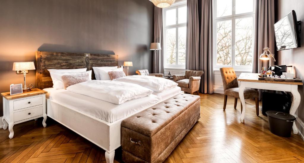 a bedroom with a large white bed and a desk at Hotel Alsterblick in Hamburg