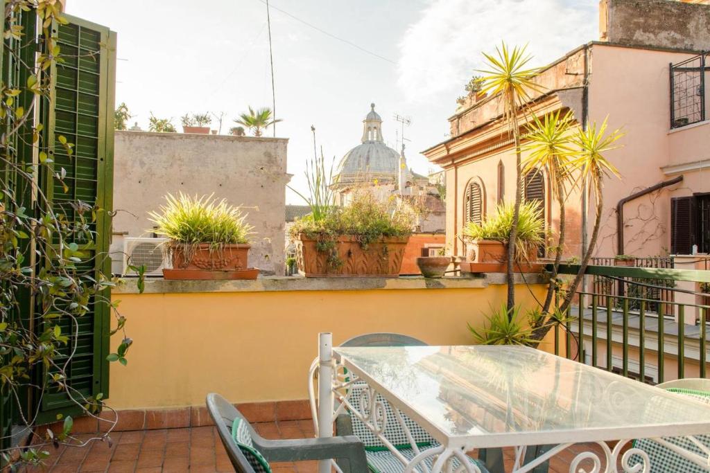 a patio with a table and chairs on a balcony at Coliseum top floor with terrace and view in Rome