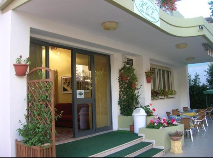 una casa con patio arredato con tavolo e sedie di Hotel Carmen Viserba a Rimini