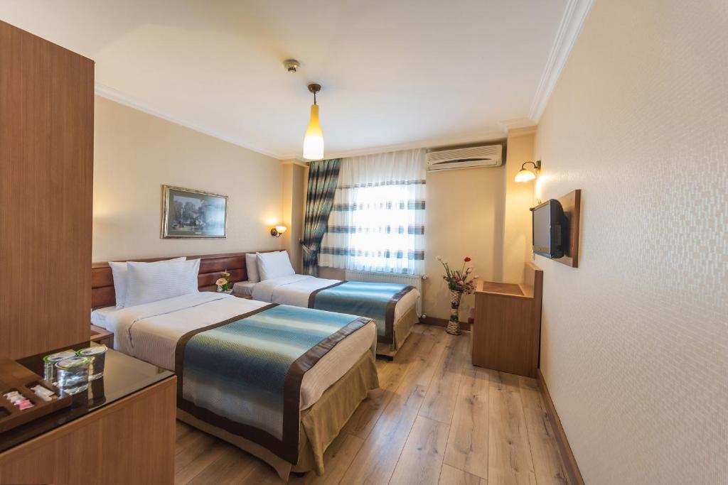 a hotel room with two beds and a couch at Senabil Hotel Old City & Spa in Istanbul