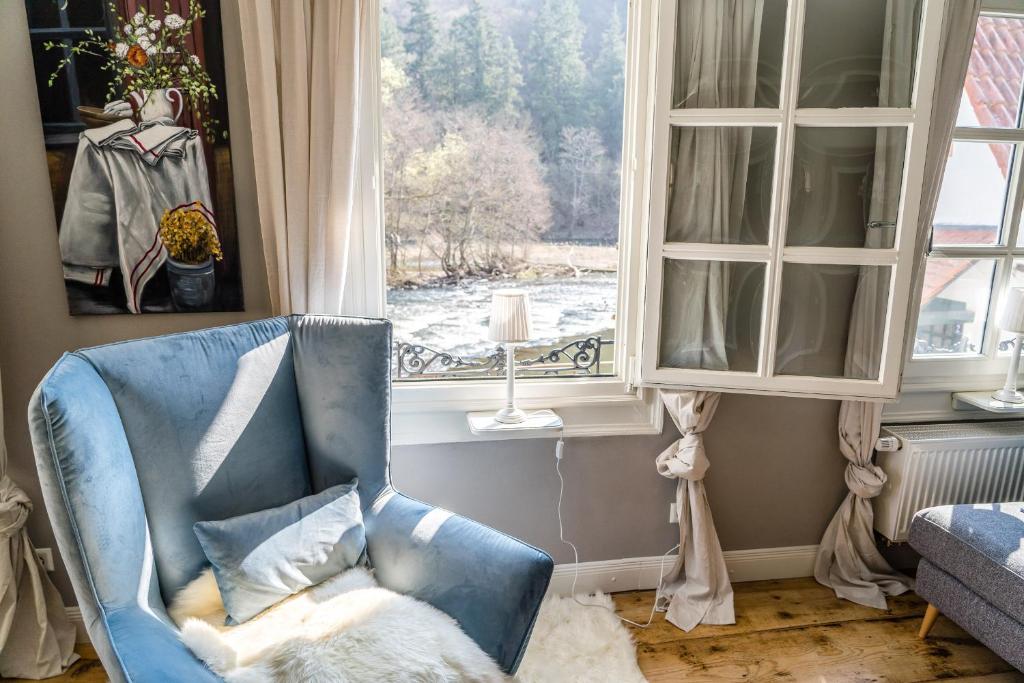 a blue chair sitting in front of a window at Ferienhaus am Fluss. Baubiologisch renoviert. in Bad Kreuznach