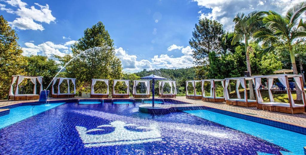 a swimming pool with a fountain in the middle at Pratas Thermas Resort in São Carlos