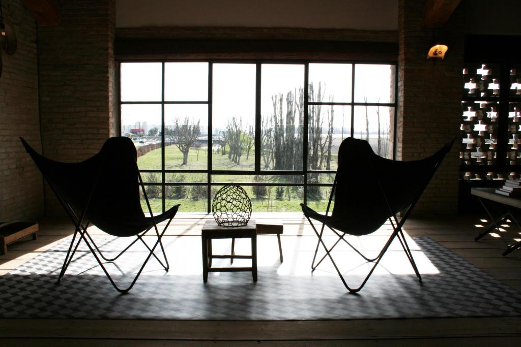 2 sillas y una mesa en una habitación con ventanas en B&B Rocambola, en Nogara