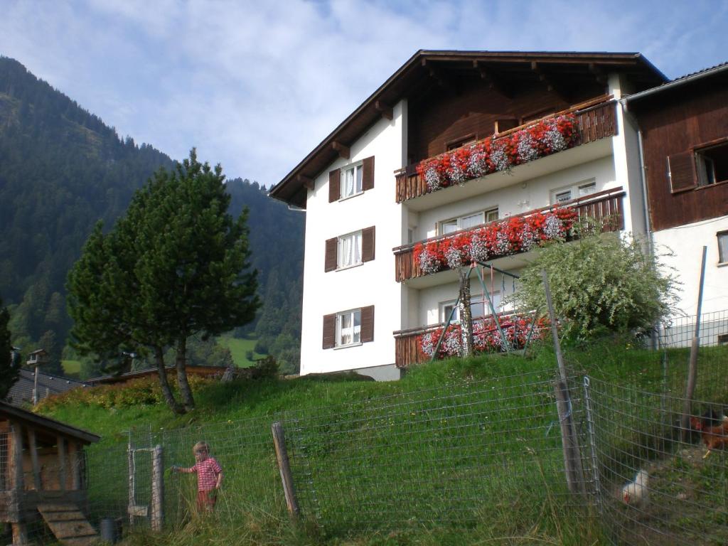 une personne debout devant un bâtiment dans l'établissement Berghof Latzer, à Gurtis