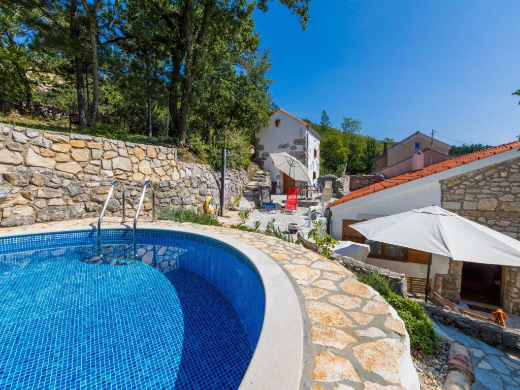 a swimming pool in front of a stone wall at House VILLA NINA in Tribalj
