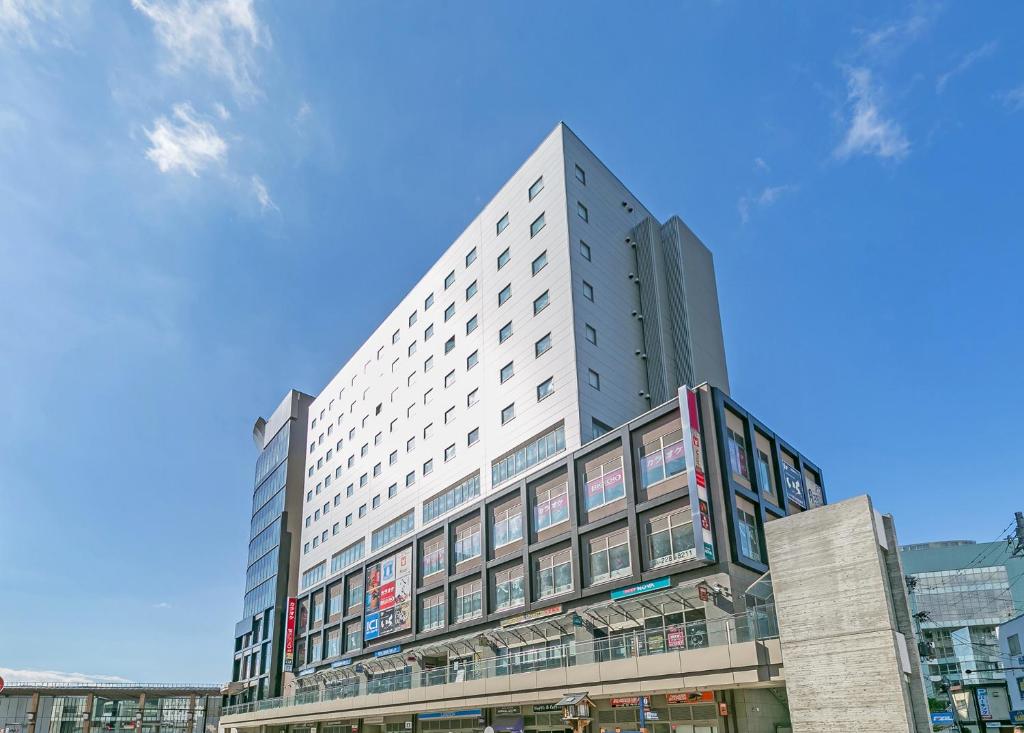 a large building with a clock on the side of it at Sotetsu Fresa Inn Nagano-Zenkojiguchi in Nagano