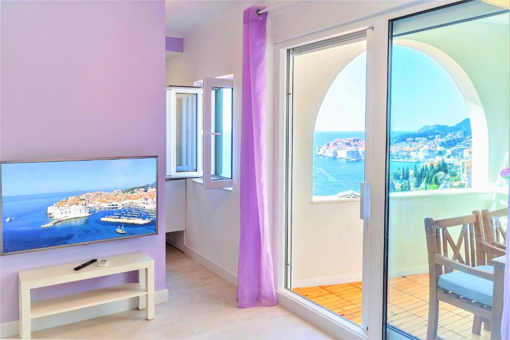 a living room with a tv and a balcony at Dubrovnik Colors - Old Town View Apartment No1 in Dubrovnik