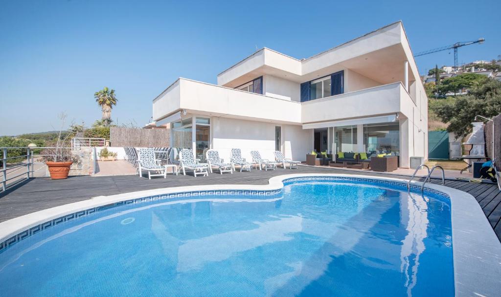 a swimming pool in front of a house at Villa Med in Sitges
