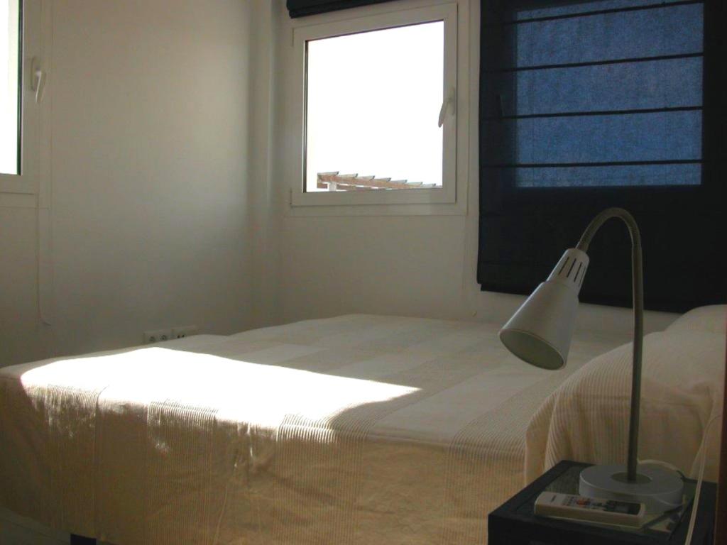 a bedroom with a bed with a lamp and a window at Apartamentos Guga RTA A CA 00267 AT Edif Complejo 2 Llaves Playa in Conil de la Frontera