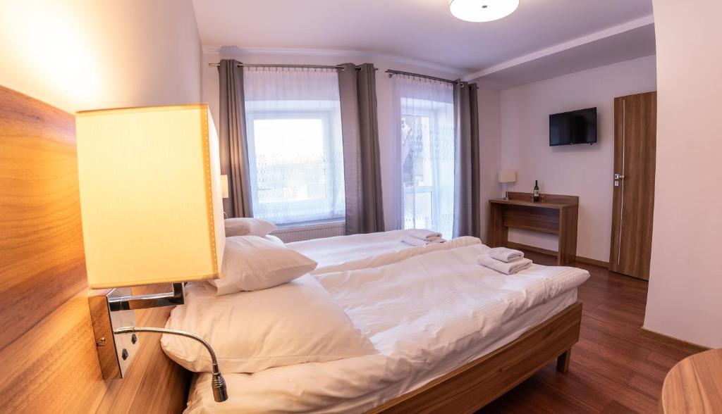 a bedroom with a bed with a lamp on it at Apartamenty ZYGFRYD 28C 2 in Bystrzyca Kłodzka