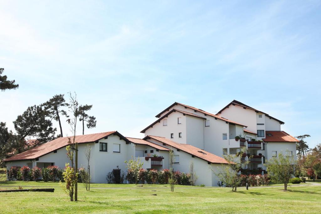 un gran edificio blanco con techos rojos en VVF Résidence Anglet en Anglet