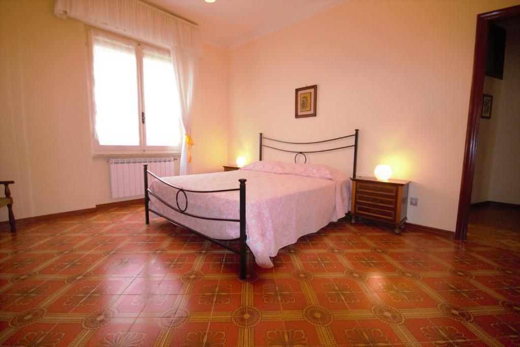 a bedroom with a bed with pink sheets and a window at Casa vacanza Francesca in Levanto