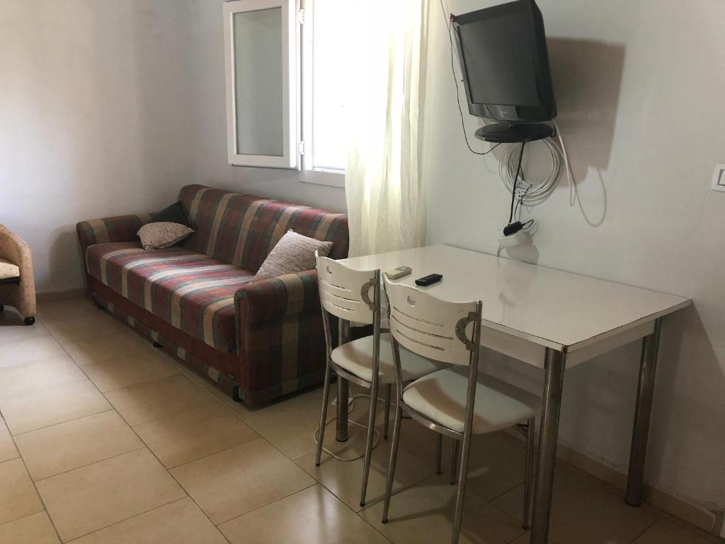 a living room with a couch and a table and a tv at Gunes tatil köyü in Bademli
