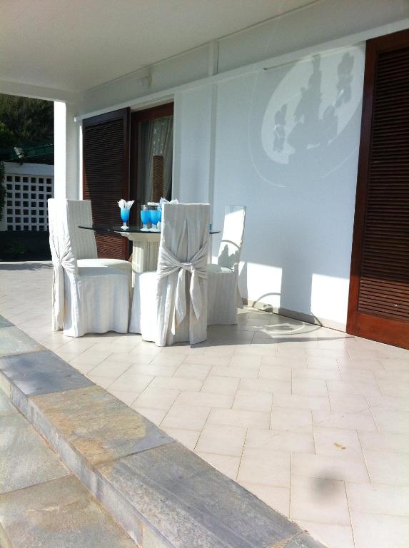 d'une terrasse avec 2 chaises blanches et une table. dans l'établissement Nerantza Villa Jolimax, à Nerántza