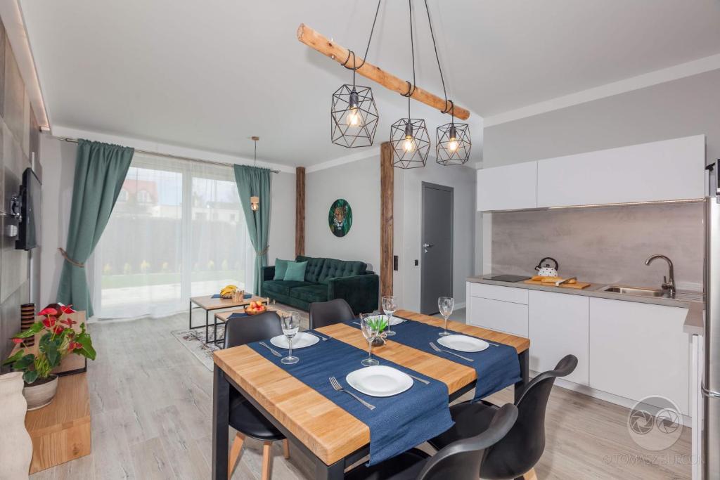 kuchnia i jadalnia ze stołem i krzesłami w obiekcie Apartament Natura I we Władysławowie