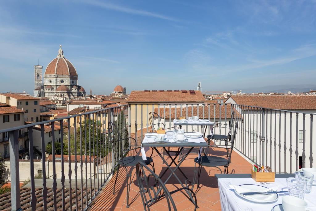 a patio area with chairs, tables, and umbrellas at Palazzo Graziani in Florence