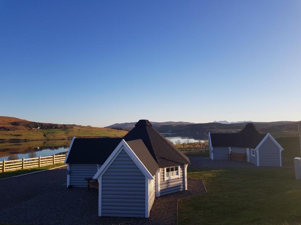 un grupo de cabañas sentadas en la cima de un campo en Skye Cabins, en Skeabost