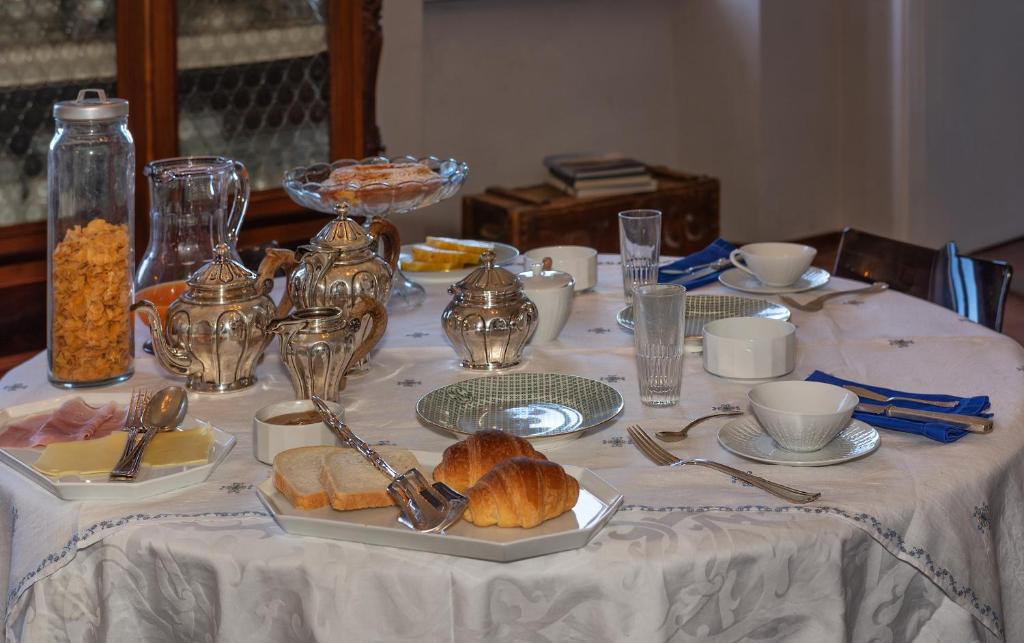 a table with a white table cloth with food on it at Villa Eugenia in Livorno