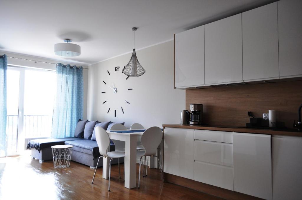 uma cozinha e uma sala de estar com um sofá e uma mesa em Apartament , Bałtycka 11 em Kolobrzeg