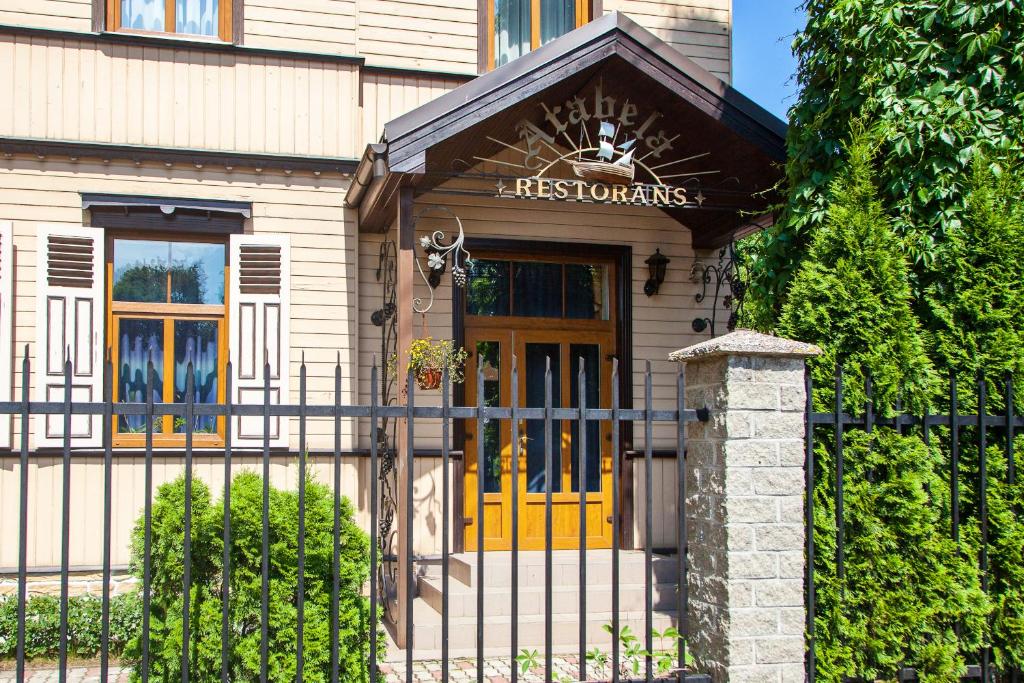 a house with a yellow door and a fence at Arabela in Rīga