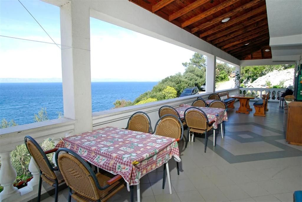 un patio con mesas y sillas y el océano en Winery Bačić, en Blato