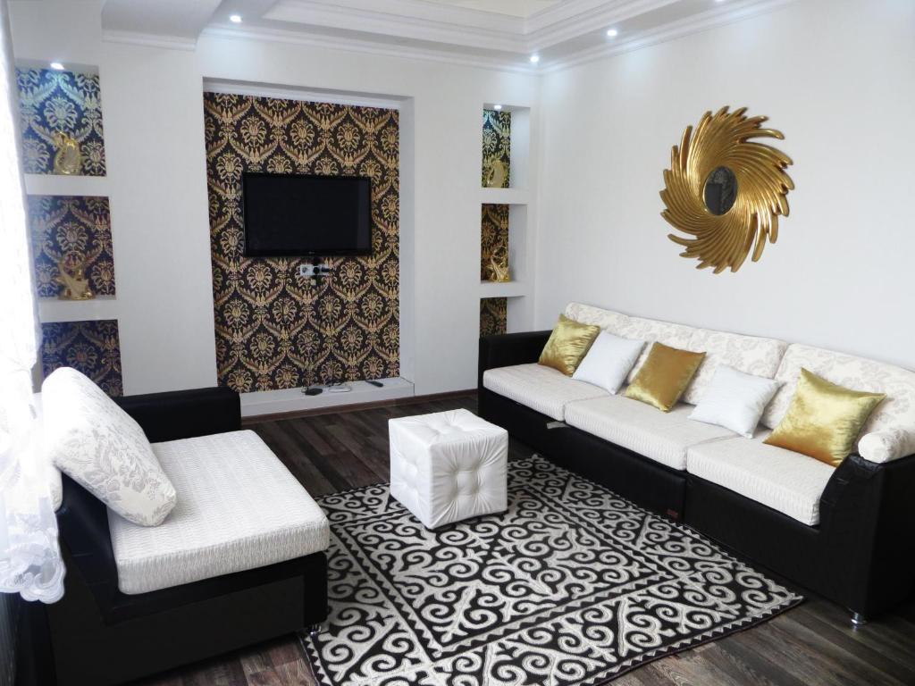een woonkamer met een bank en een tv bij Comfort Apartment in Bisjkek