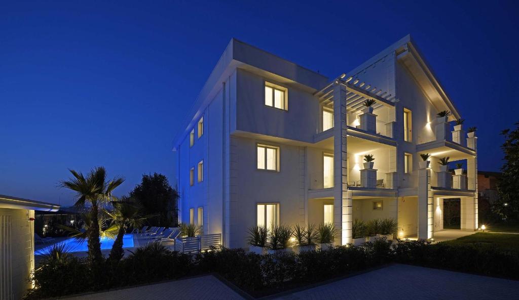 a large white building at night with lights at Villa Bianca Luxury Apartments in Desenzano del Garda