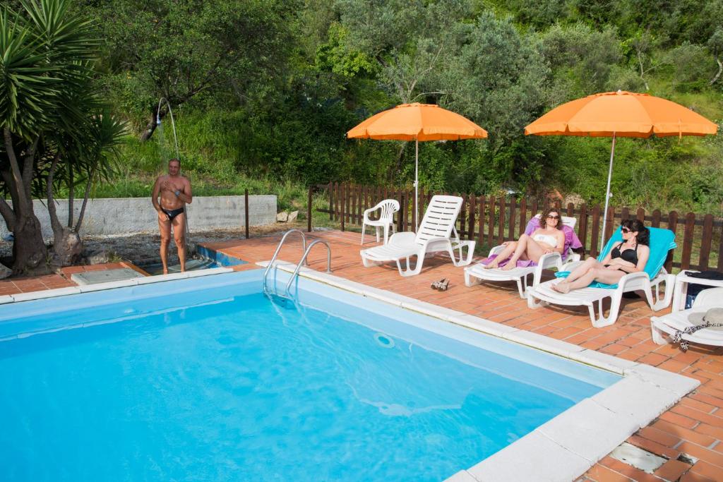 un gruppo di persone seduti intorno alla piscina di Fattoria Cristina Bilo Rosa a Castelnuovo di Magra