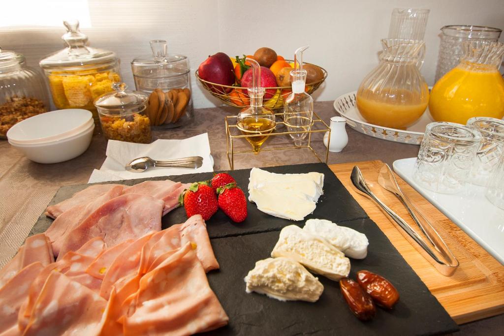 a table with food on a cutting board with strawberries and cheese at Garda Room in Peschiera del Garda