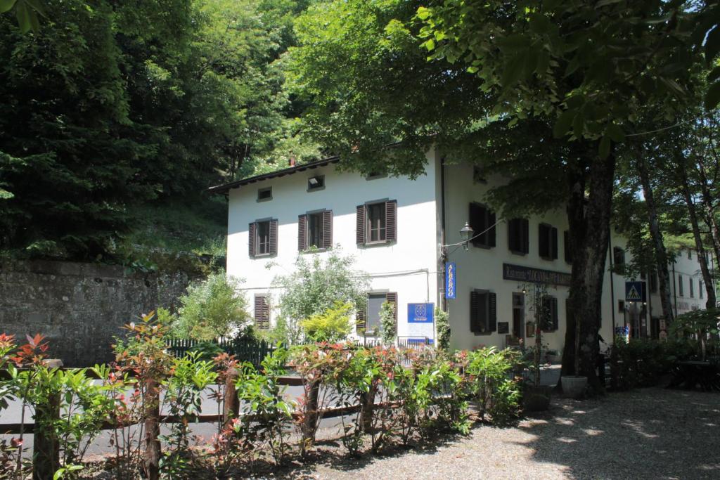 a white house with a fence and flowers at Locanda Dei Baroni - Antica Dimora in Camaldoli