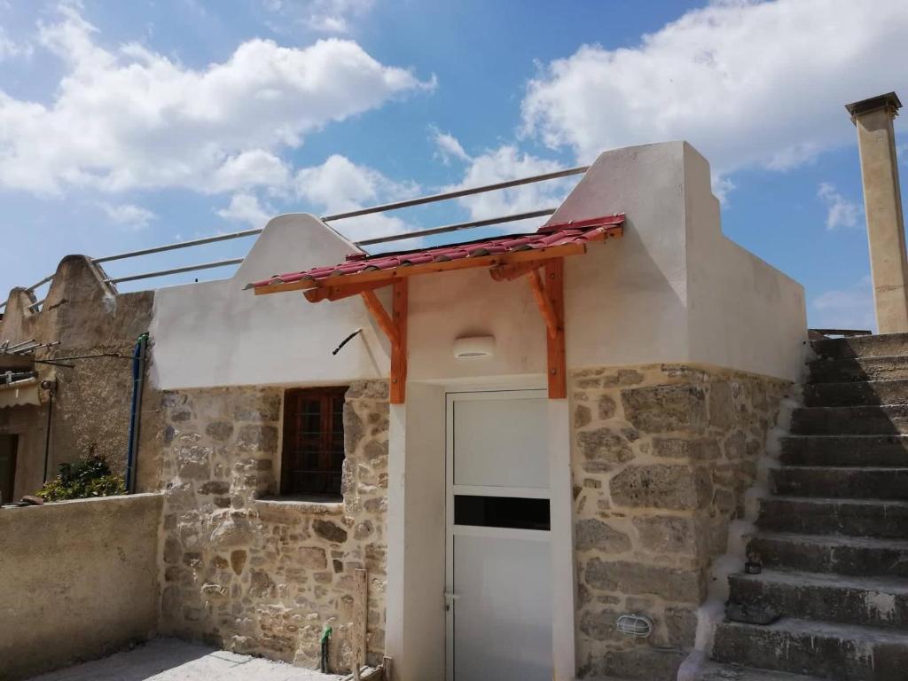 a house with a white door and some stairs at Papas Apartments in Moírai