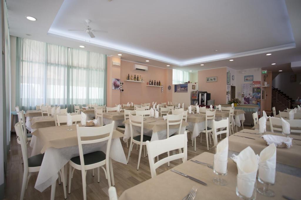 ein Esszimmer mit weißen Tischen und weißen Stühlen in der Unterkunft Hotel Madrid in Cattolica