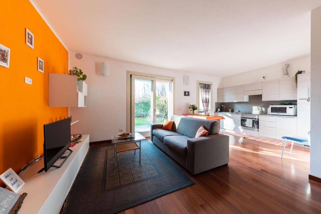 salon z kanapą i kuchnią w obiekcie Oasi w Bergamo