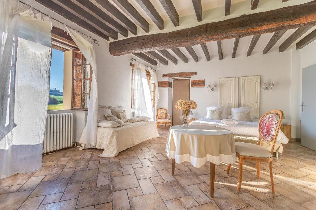 - une chambre avec un lit, une table et des chaises dans l'établissement Le Colombier de Hanches - Teritoria, à Hanches