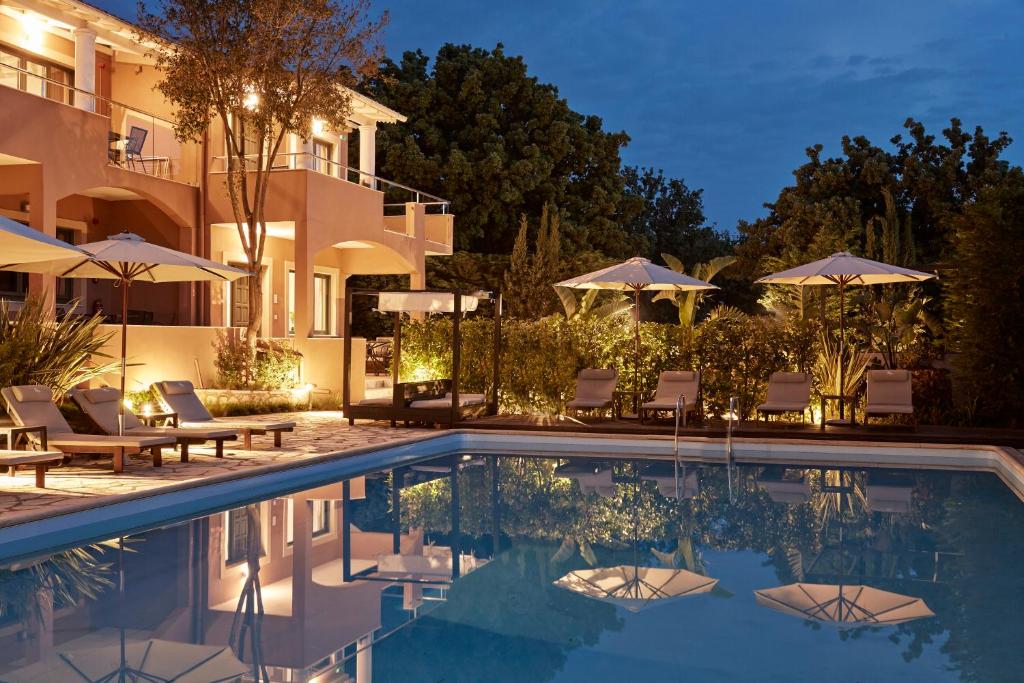 a villa with a swimming pool at night at Lena Mare Boutique Hotel in Acharavi