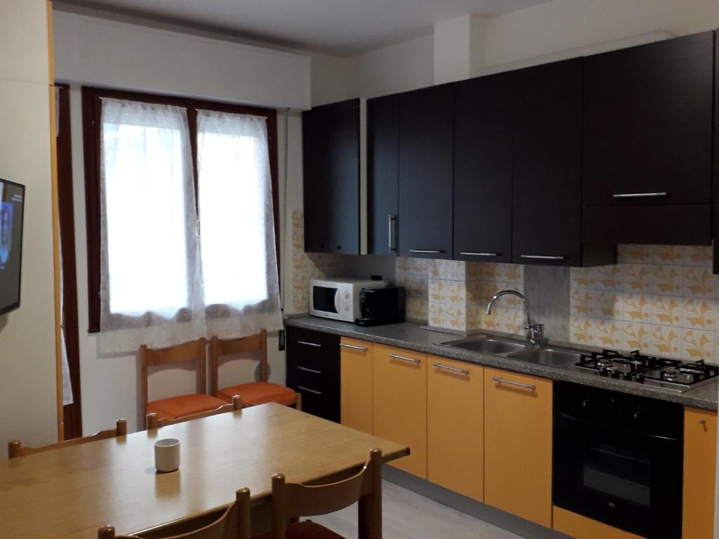 a kitchen with black cabinets and a wooden table at Appartamento al mare Lorella in Sottomarina