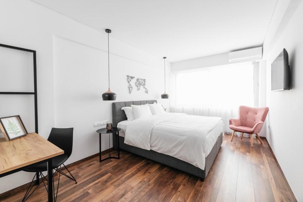 a bedroom with a bed and a desk and a table at Evapollo in Thessaloniki