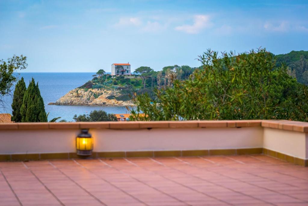 a light on a wall with a view of the ocean at Villa Madreperla in Marciana