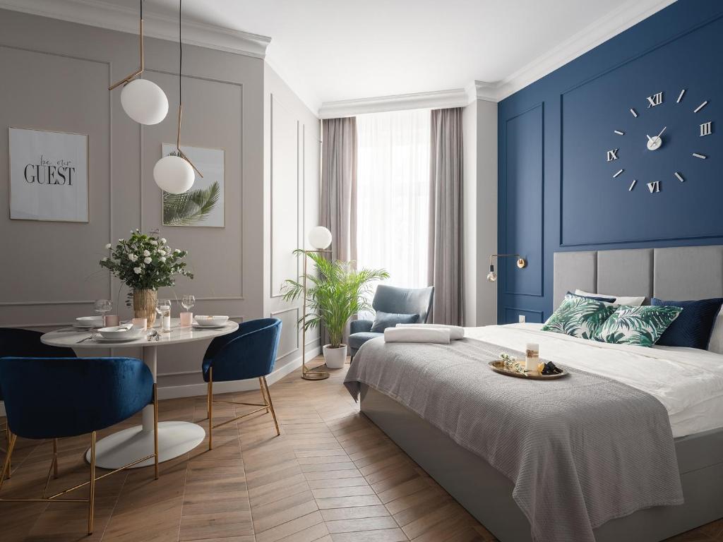 um quarto com uma cama, uma mesa e um relógio em Luxury Gold Cracow City Centre 3min Main Sq Old Town em Cracóvia