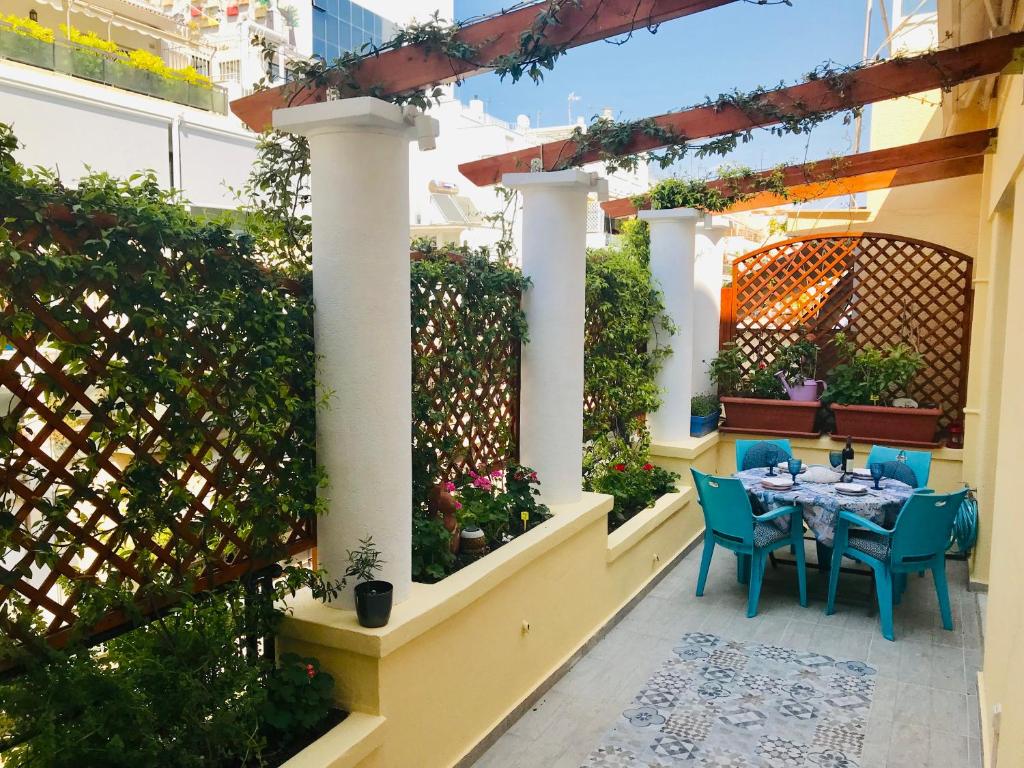 een patio met een tafel en stoelen en een hek bij Oasis veranda under columns.Kolonaki embassy area. in Athene