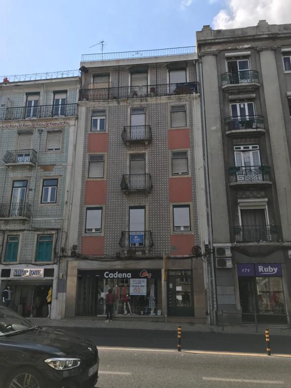 a building on a street with a car parked in front at Arroios 169 in Lisbon