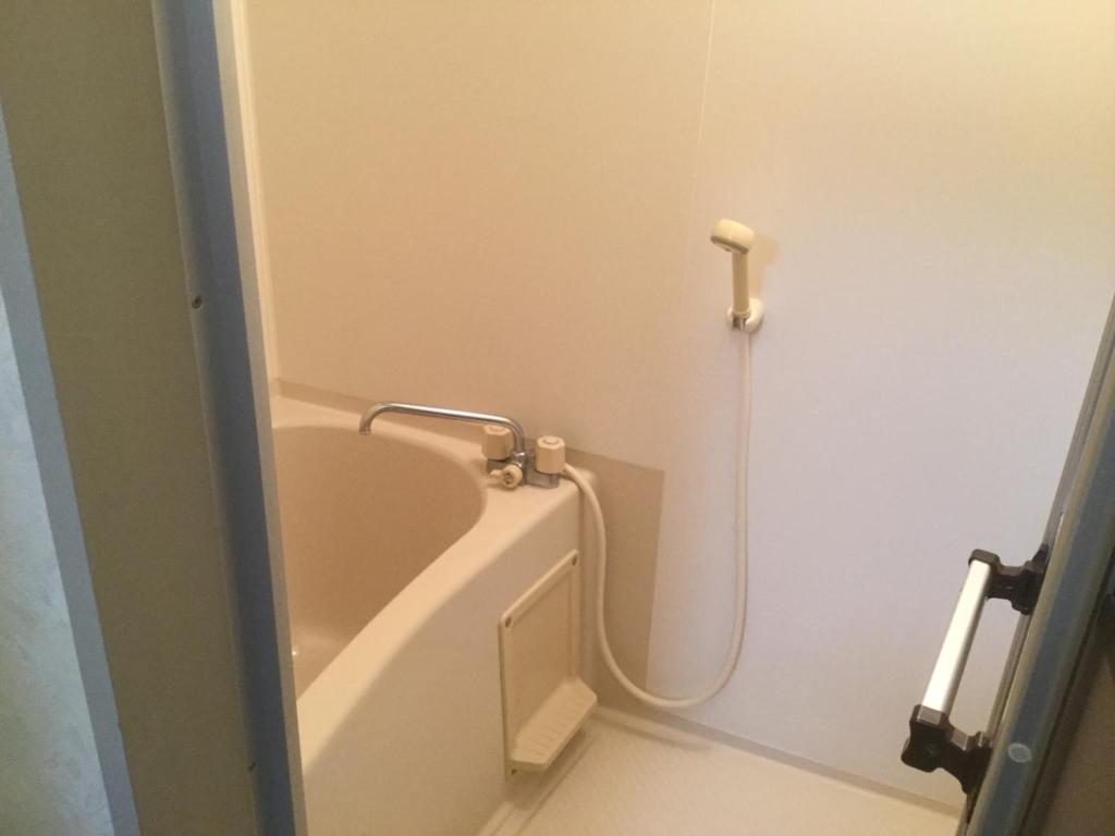La salle de bains est pourvue d'une baignoire avec un tuyau. dans l'établissement Homestay Dream / Vacation STAY 3779, à Uonuma